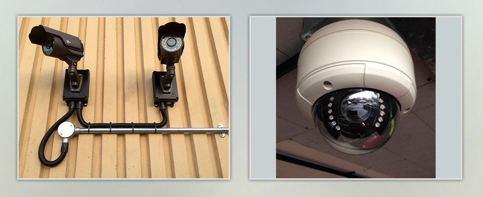 two security cameras are mounted to the side of a building