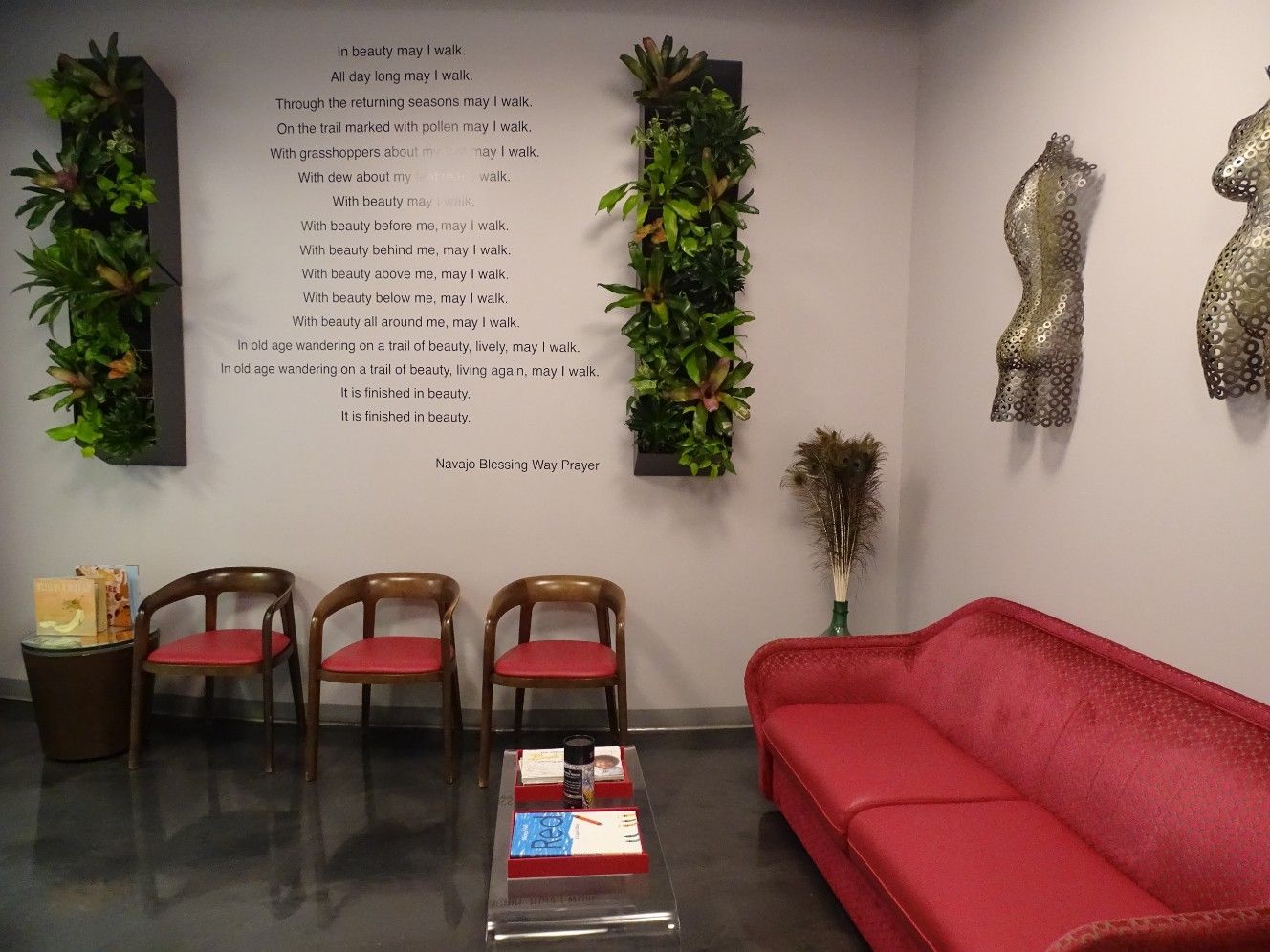The Cosmetic Concierge office waiting area with pink couch and chairs and a poem on the wall