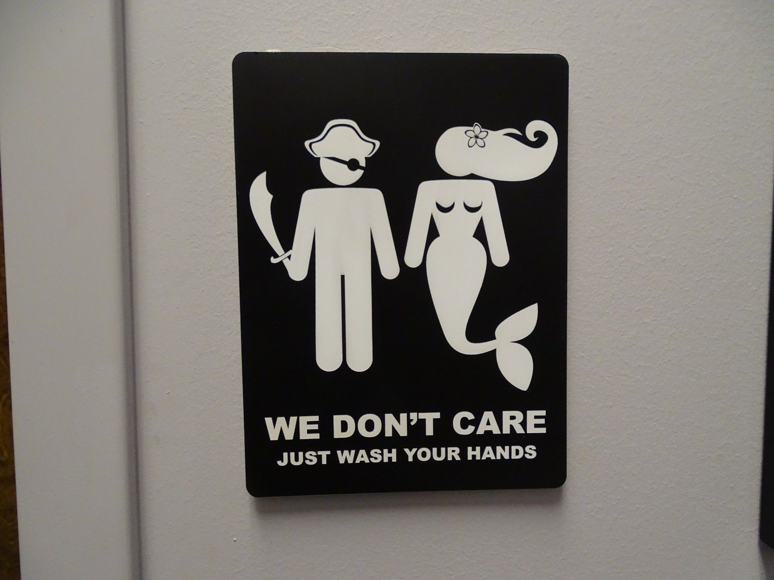 All gender friendly restroom sign with a pirate and a mermaid that says