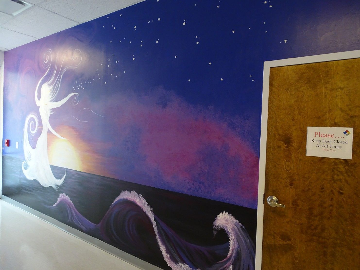 mural of ethereal woman on purple background in hallway of The Cosmetic Concierge office