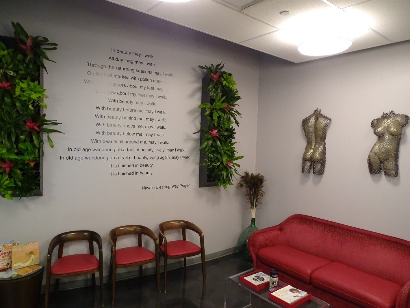 The Cosmetic Concierge office waiting area with pink couch and chairs and a poem on the wall