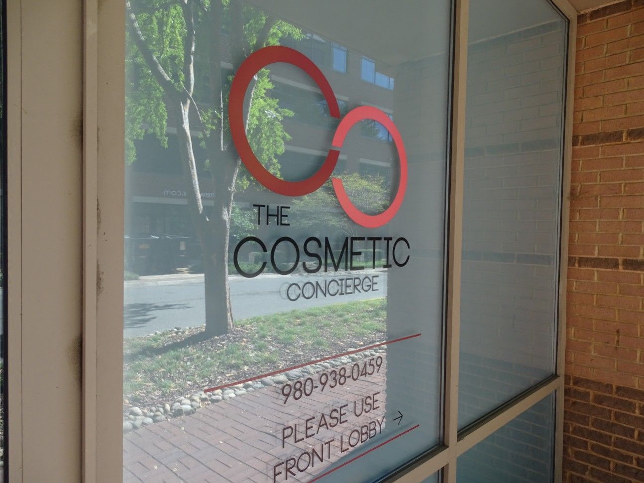A window with a sign that says the cosmetic concierge