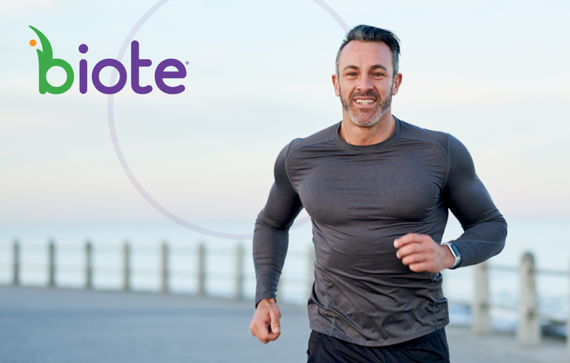 A man is running on a beach next to the ocean.