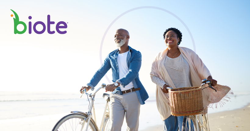 A man and a woman are riding bicycles on the beach.