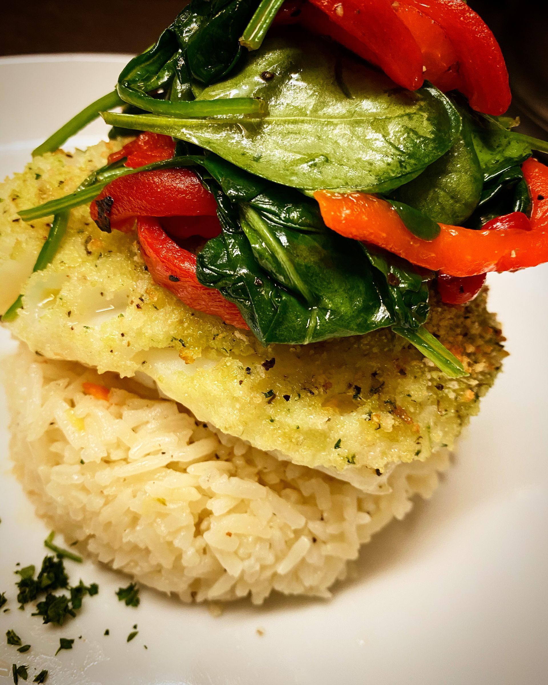 A plate of food with spinach and peppers on top of rice