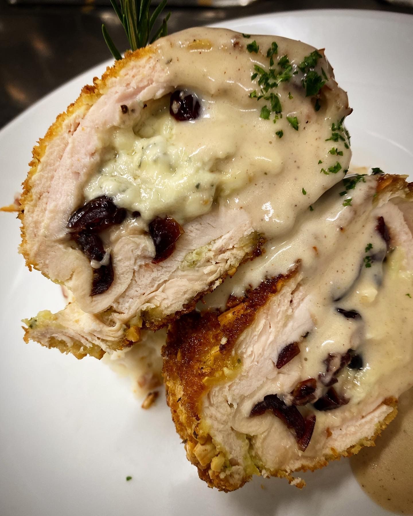 A close up of a stuffed chicken on a white plate