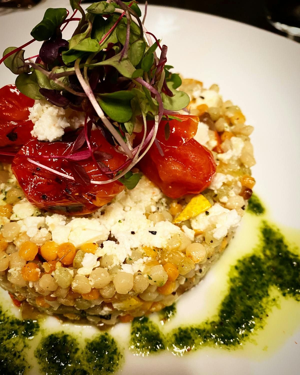 A close up of a plate of food with tomatoes and cheese