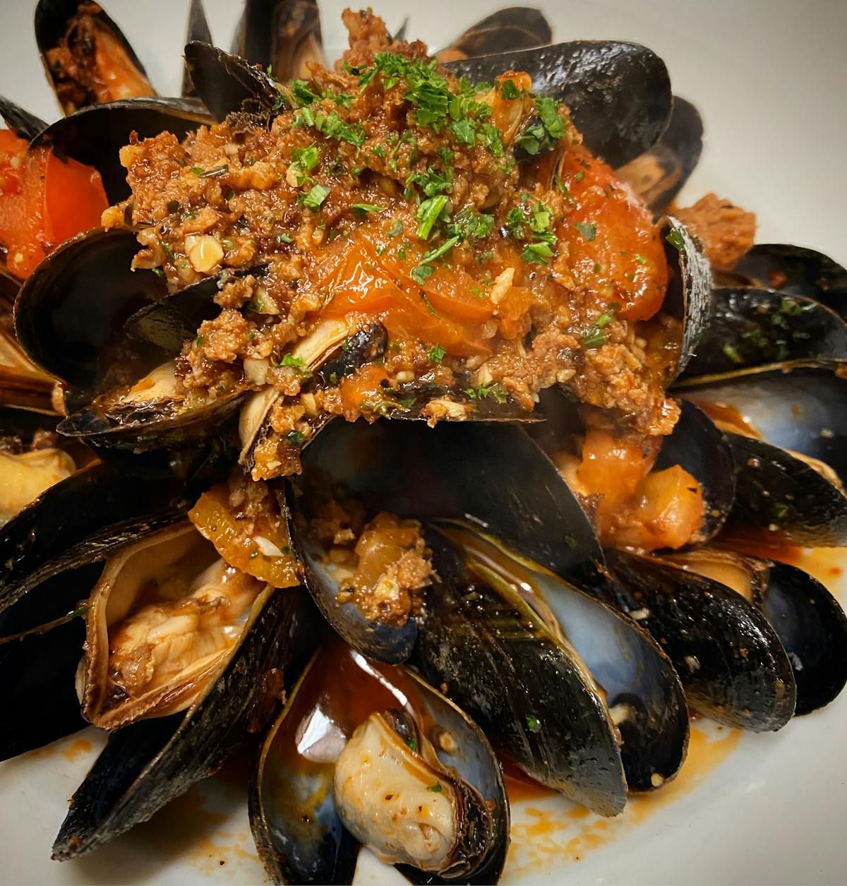 A close up of a plate of food with mussels and meat