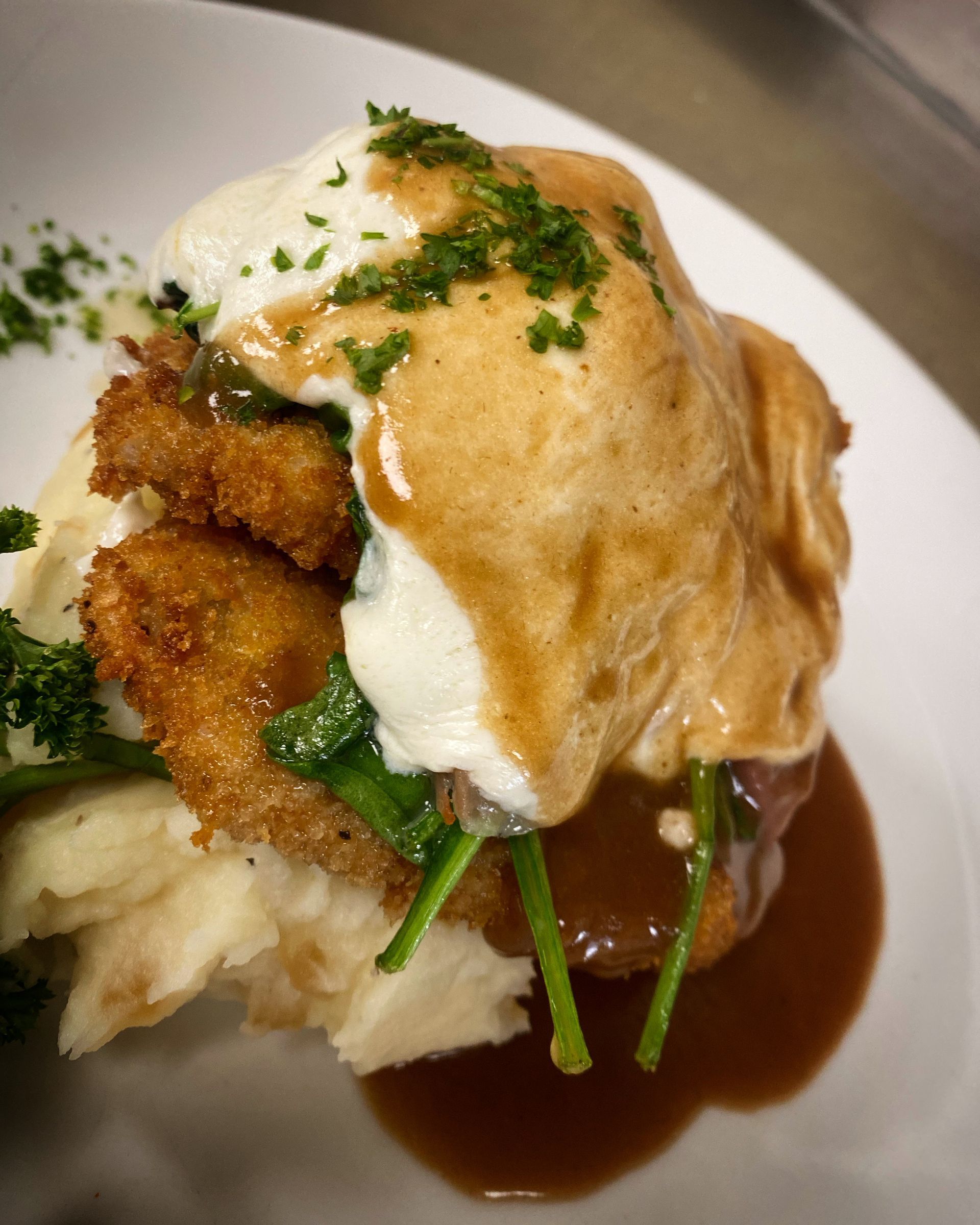 A close up of a plate of food with mashed potatoes and gravy