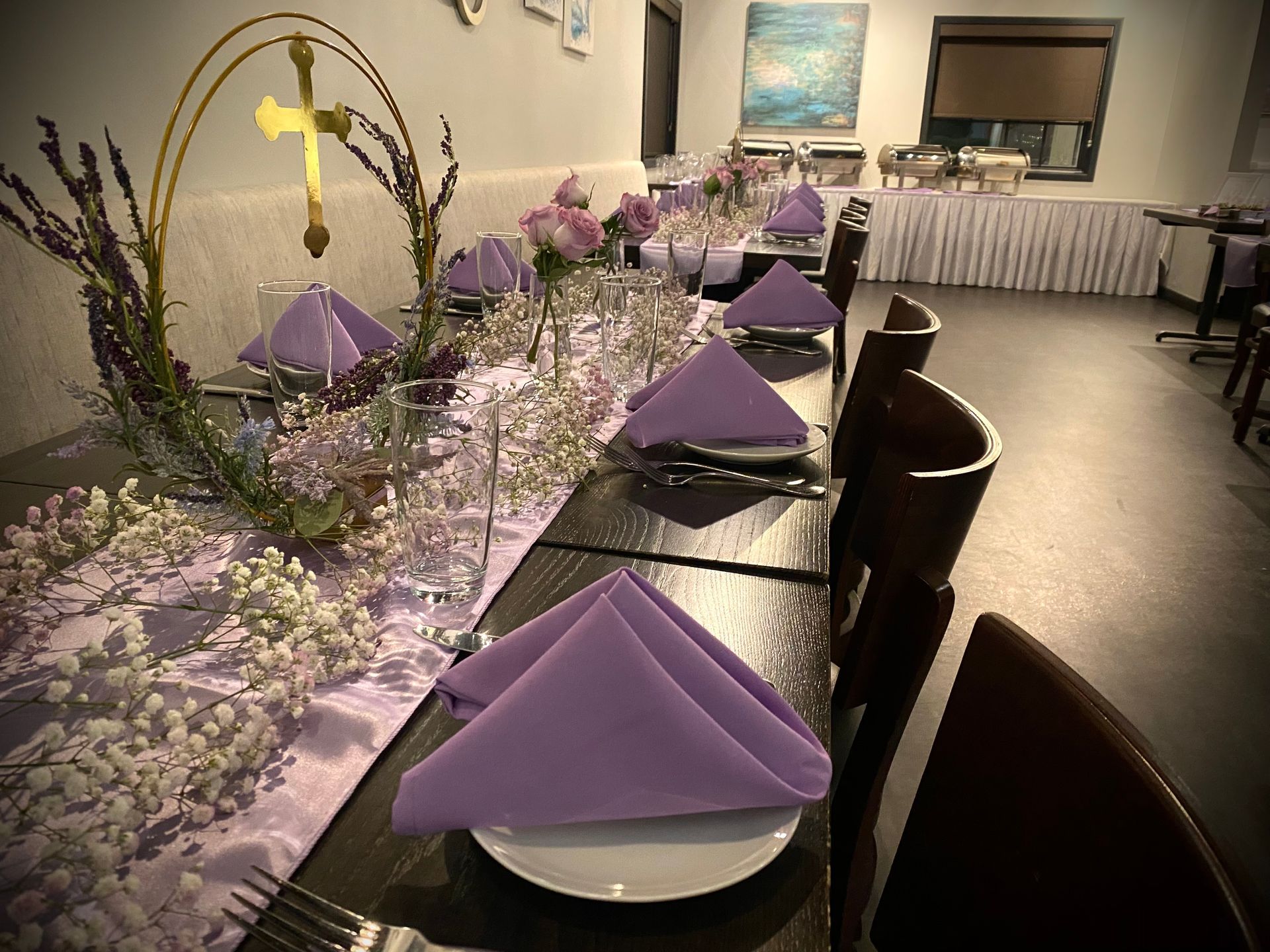 A long table with purple napkins and a cross on it