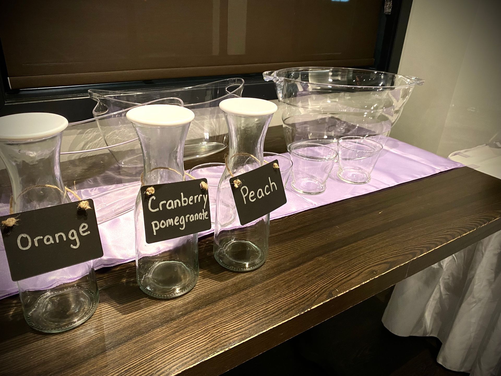 A table with bottles of orange cranberry peach and pomegranate on it.