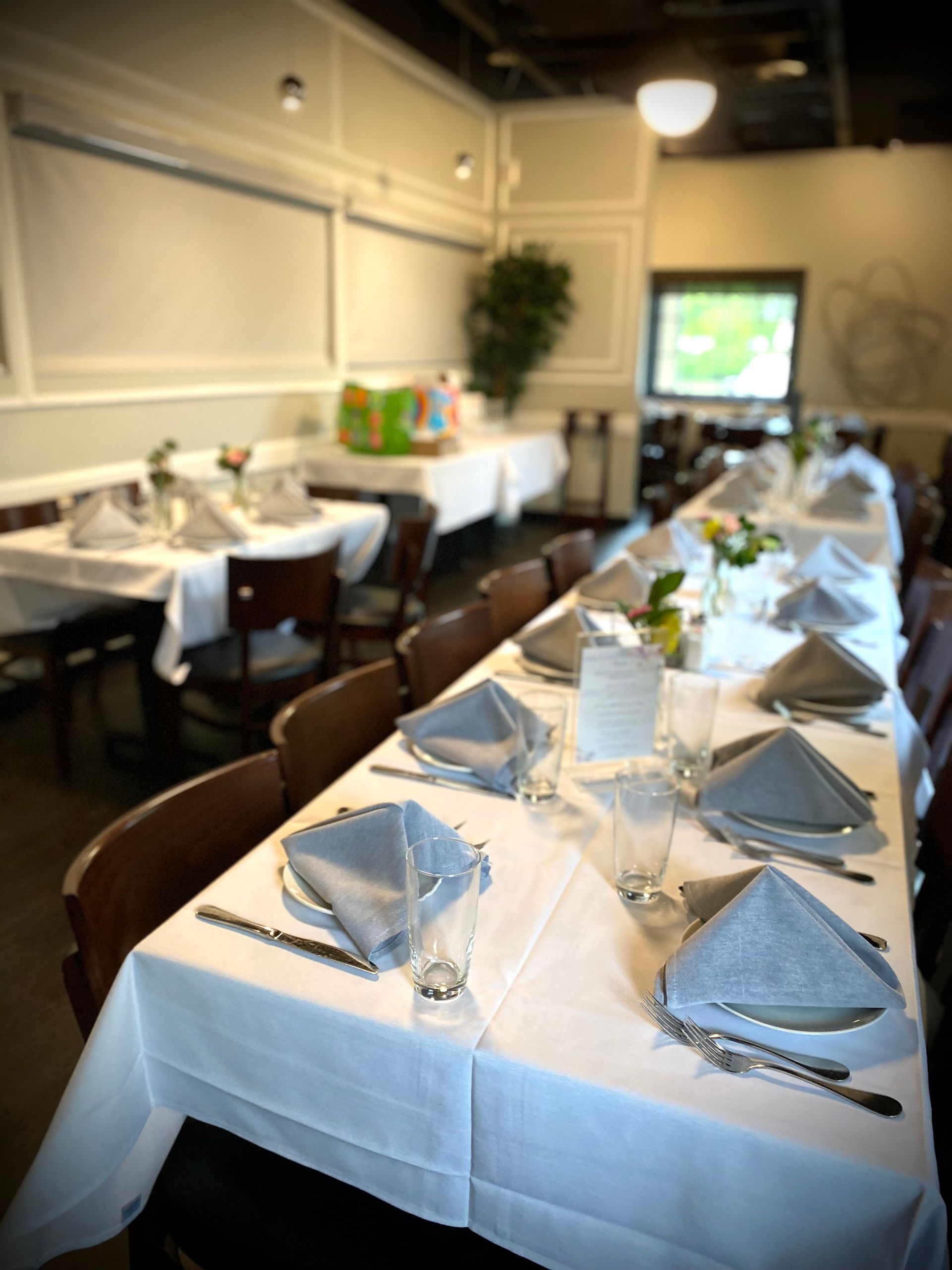 A long table with a white table cloth and silverware