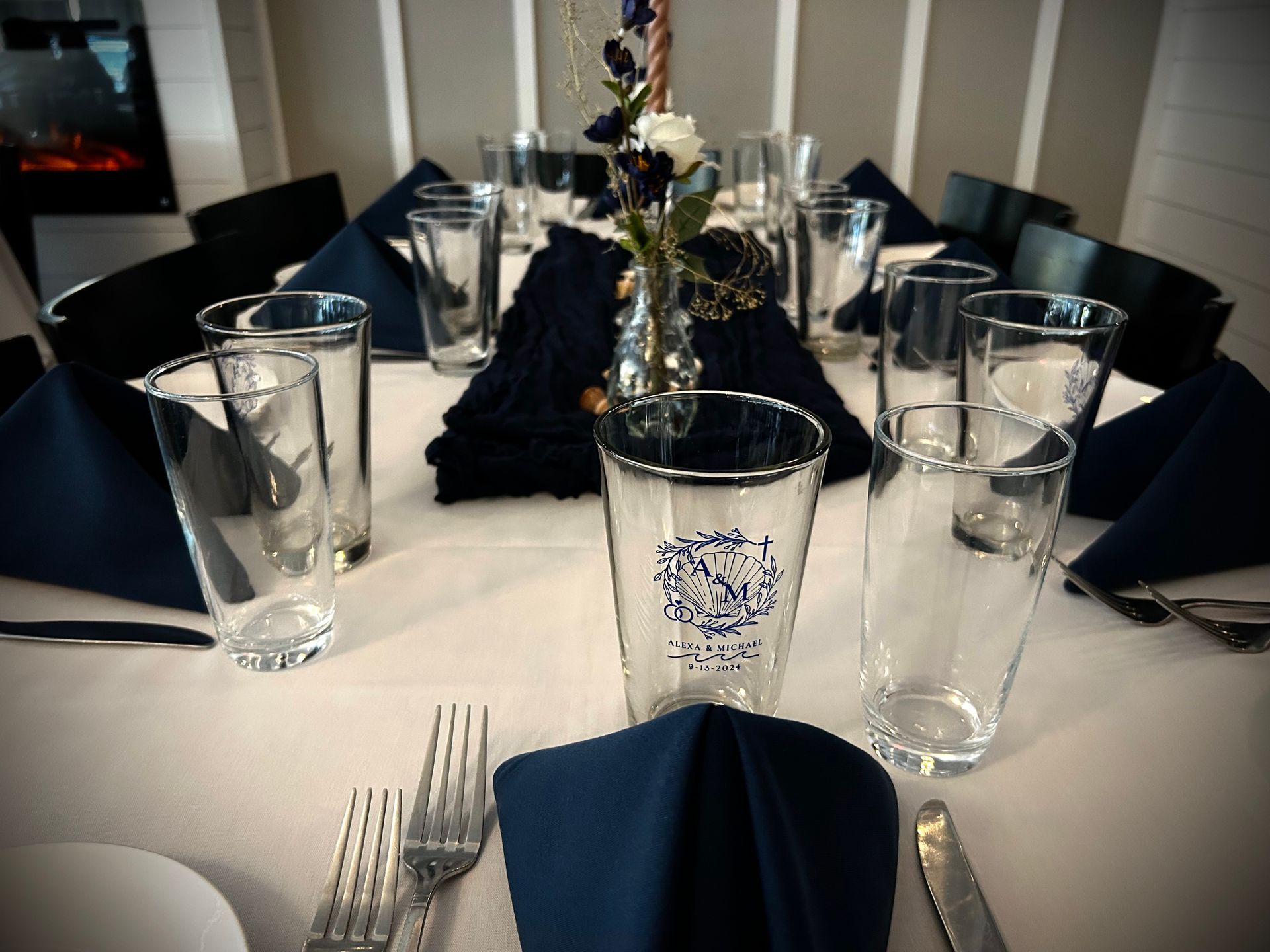 A table with a vase of flowers and glasses on it