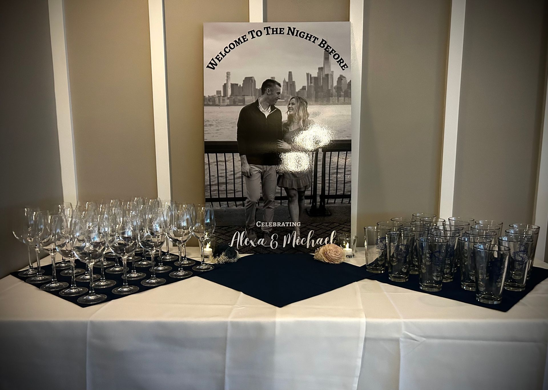 A table with a picture of a bride and groom and wine glasses on it.