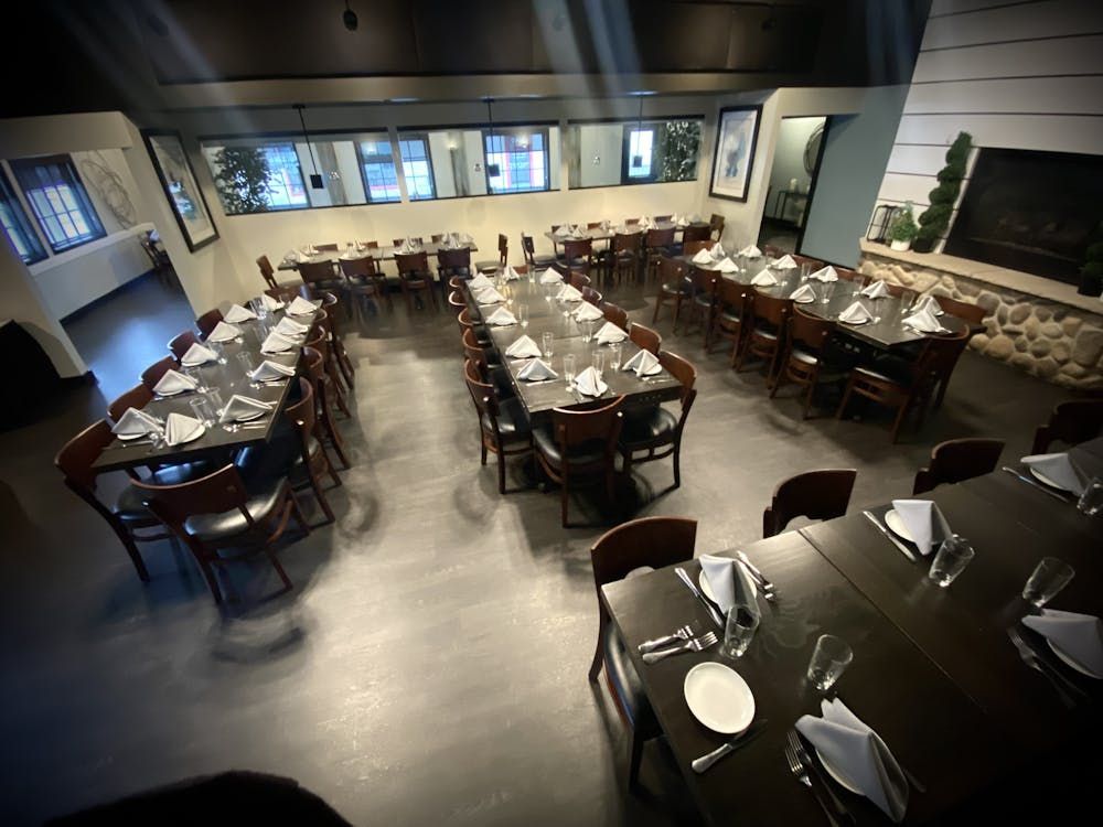 A large dining room with tables and chairs and a fireplace