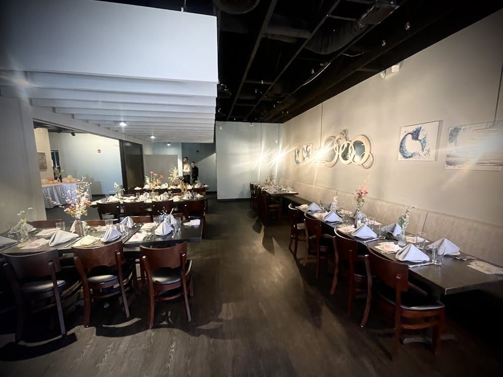 A restaurant with tables and chairs set up for dinner
