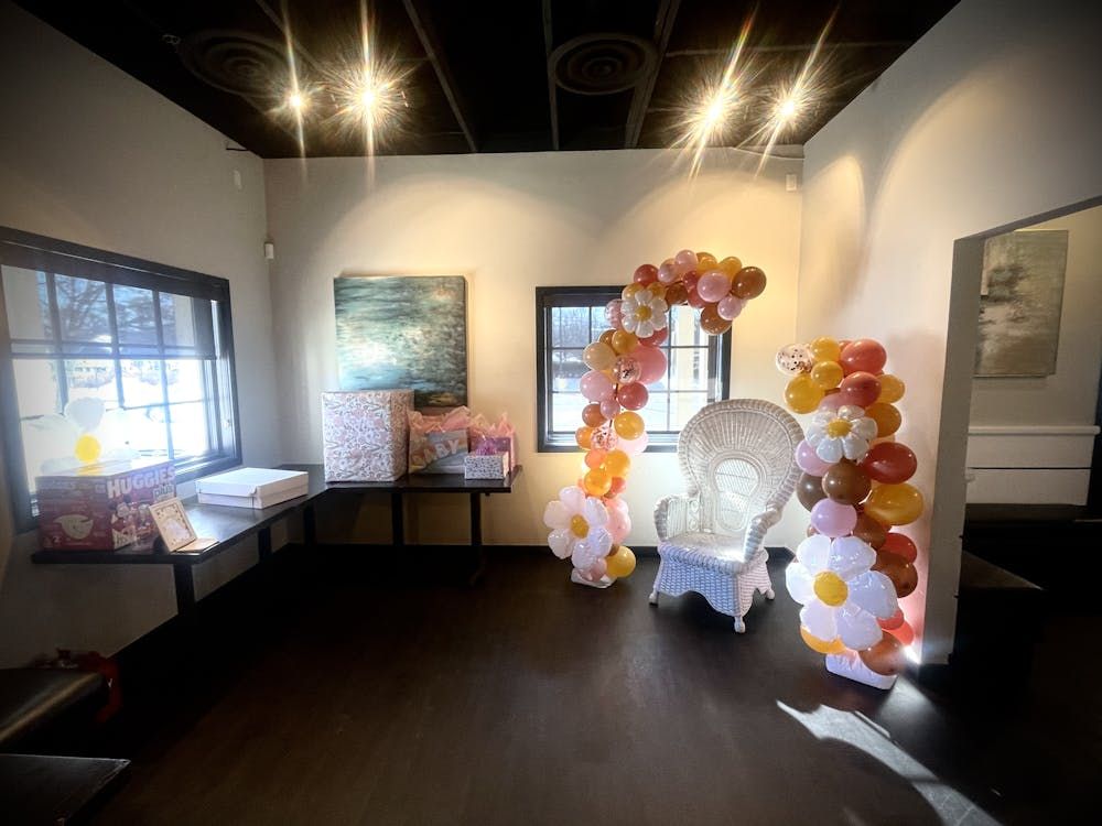 A room with a chair and balloons on the floor.