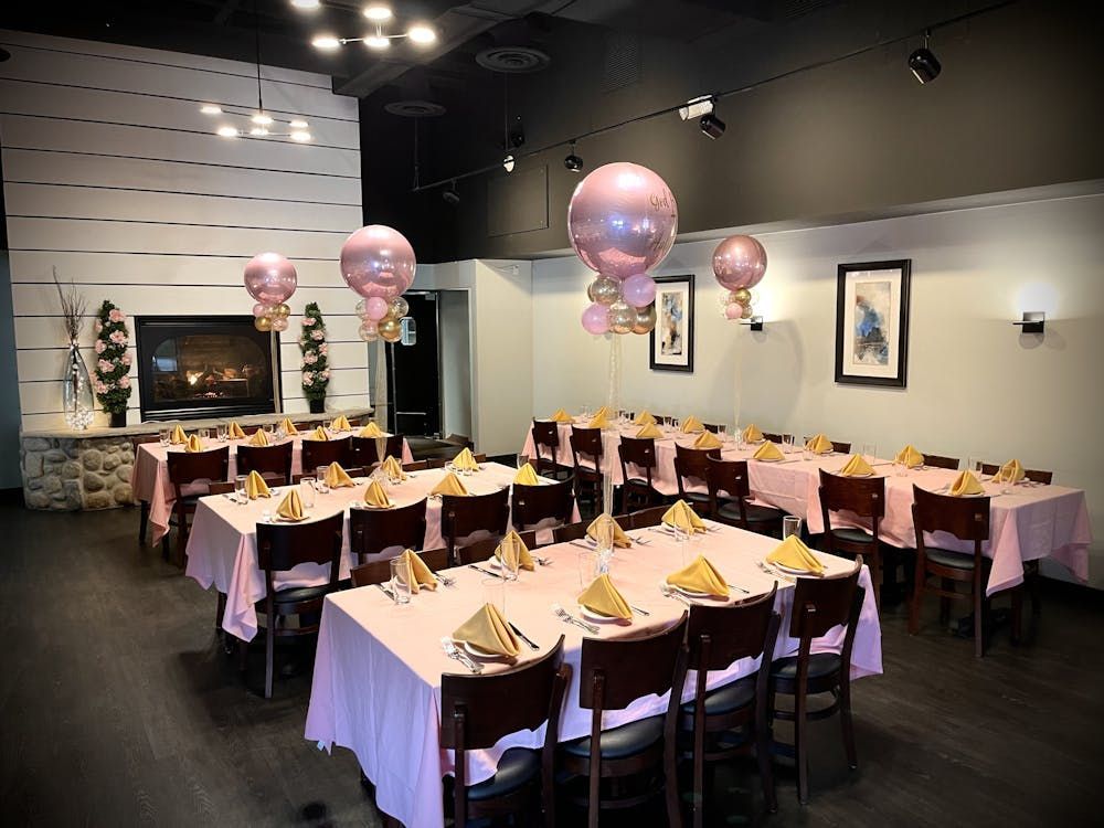 A room with tables and chairs and balloons on the ceiling