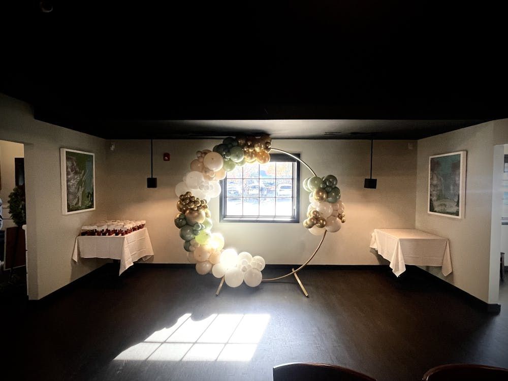 A room with a balloon arch in the middle of it.