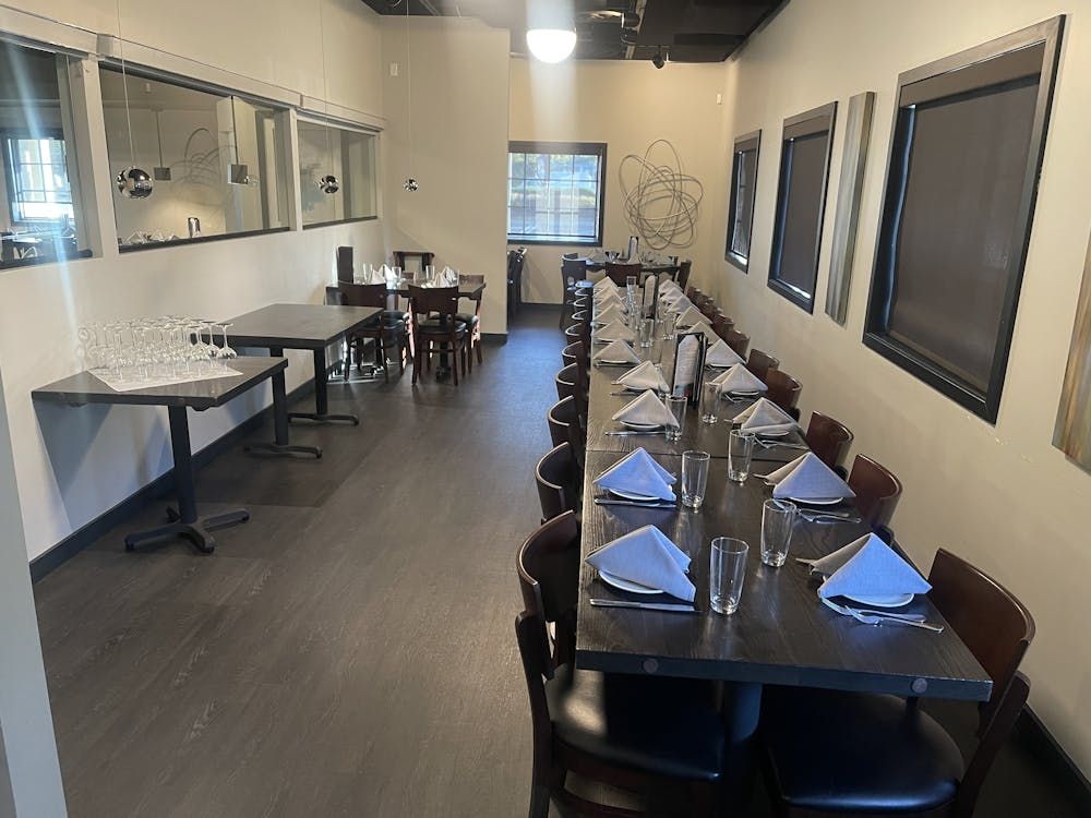 A long dining room with tables and chairs set up for a party.