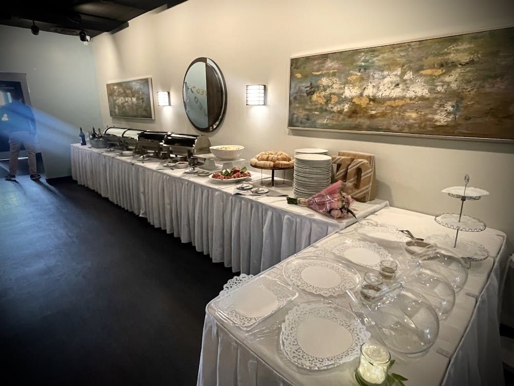 There is a long table with plates and glasses on it.
