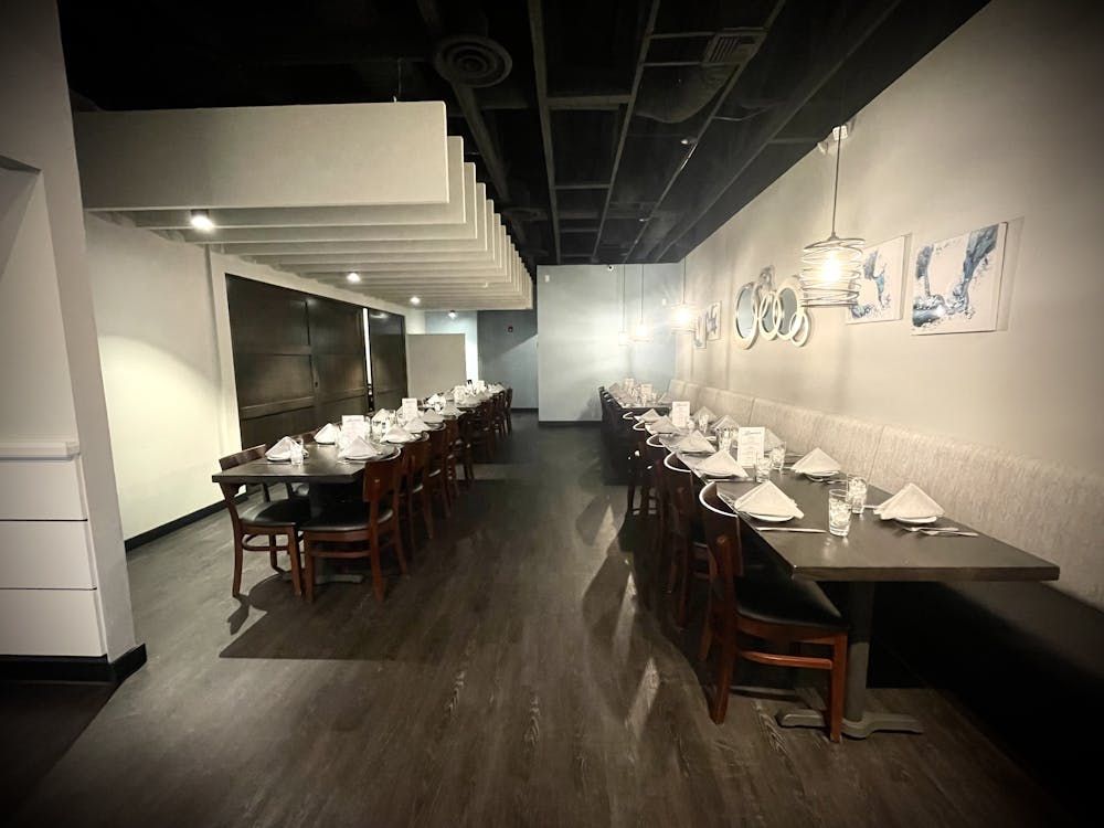 A long dining room with tables and chairs in it