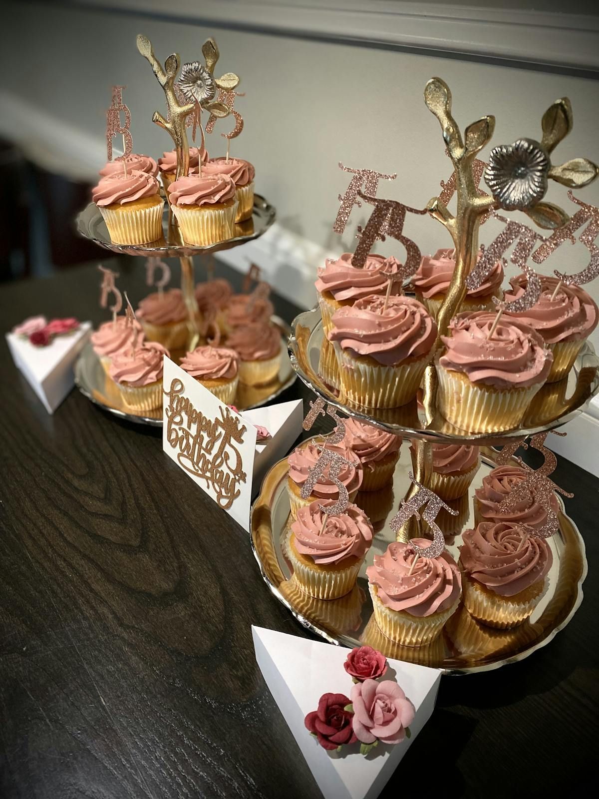 A display of cupcakes with pink frosting on a table.