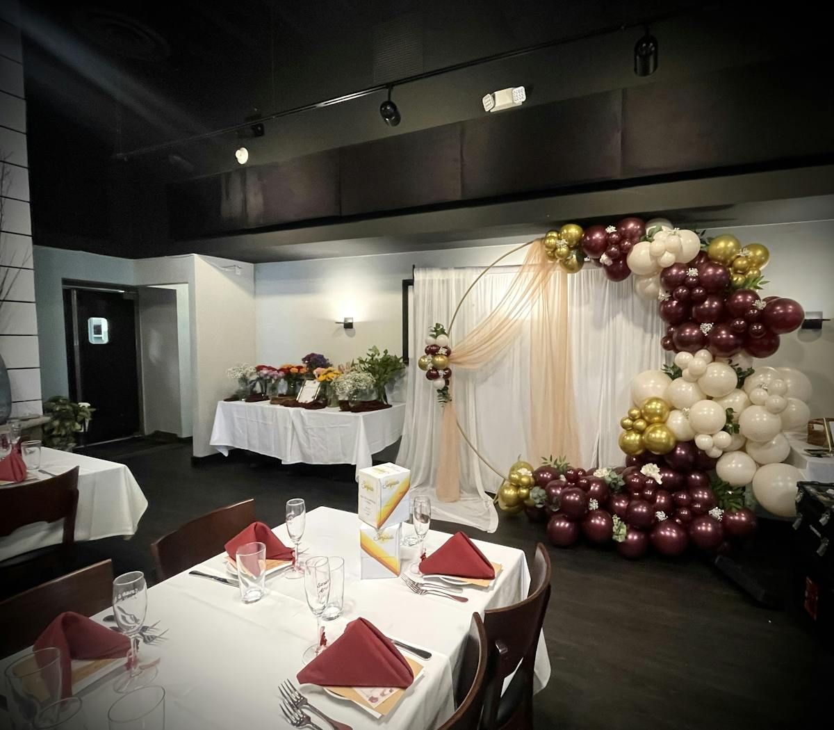 A room with tables and chairs and balloons on the wall