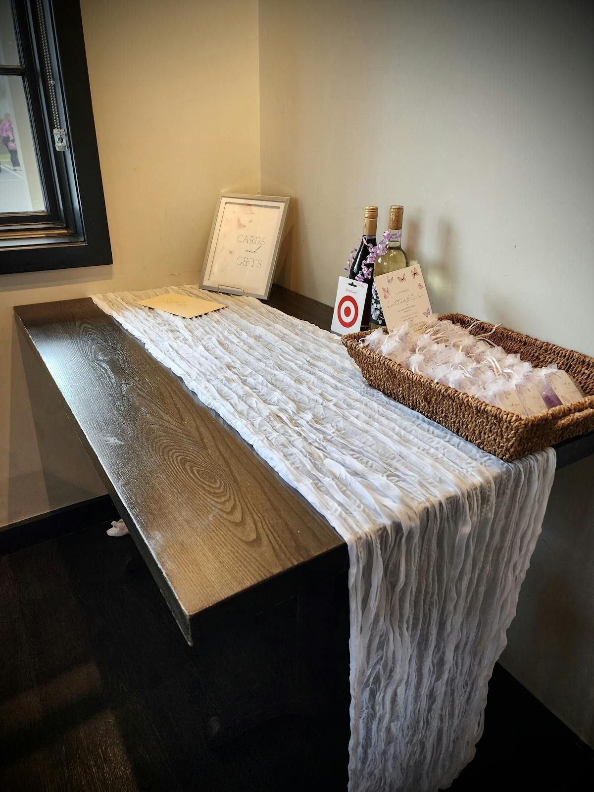 A table with a white table runner and two bottles of wine on it.