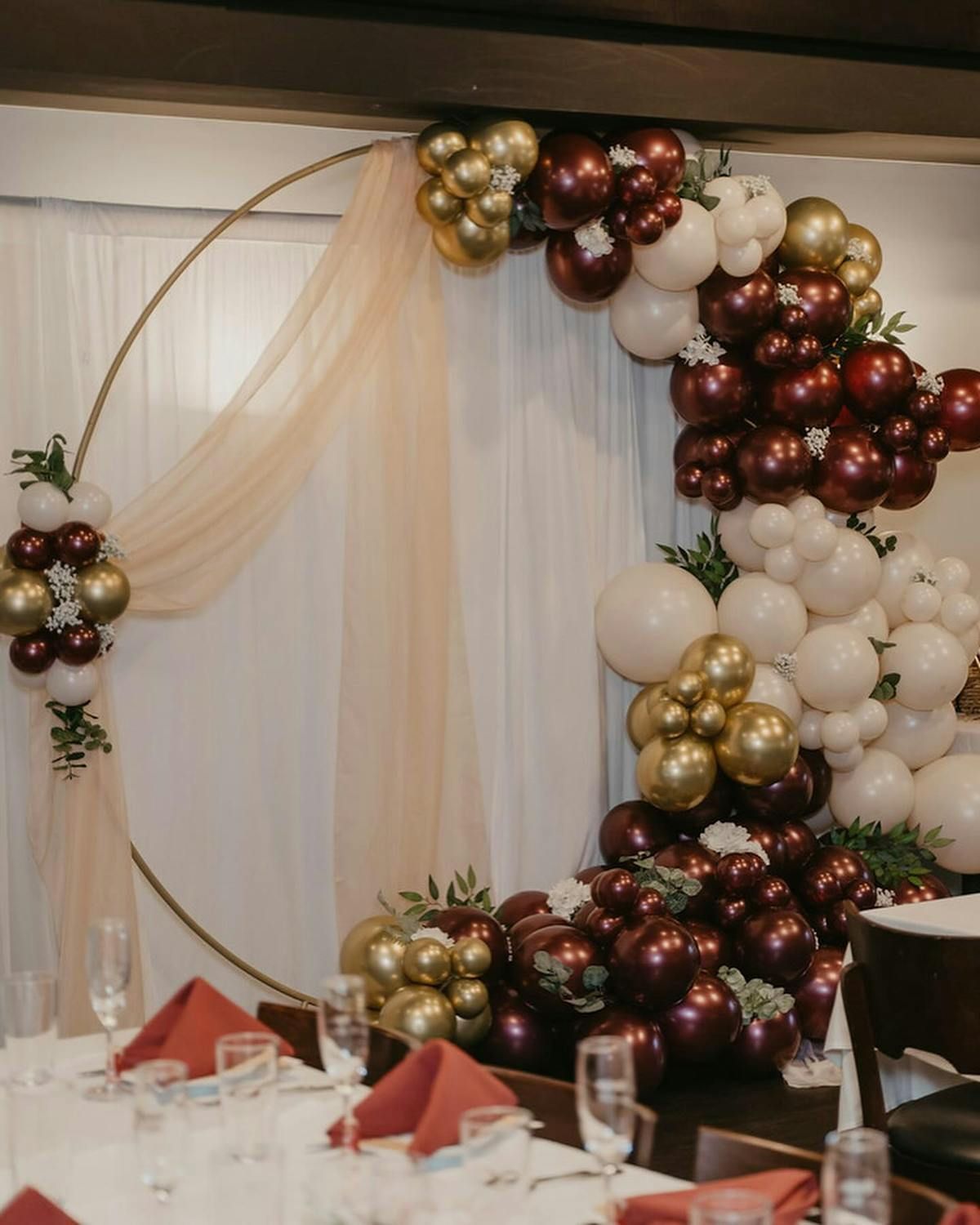 A room filled with balloons and a table with glasses and napkins.