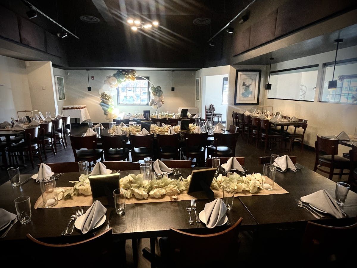 A restaurant with tables and chairs set up for a wedding reception.