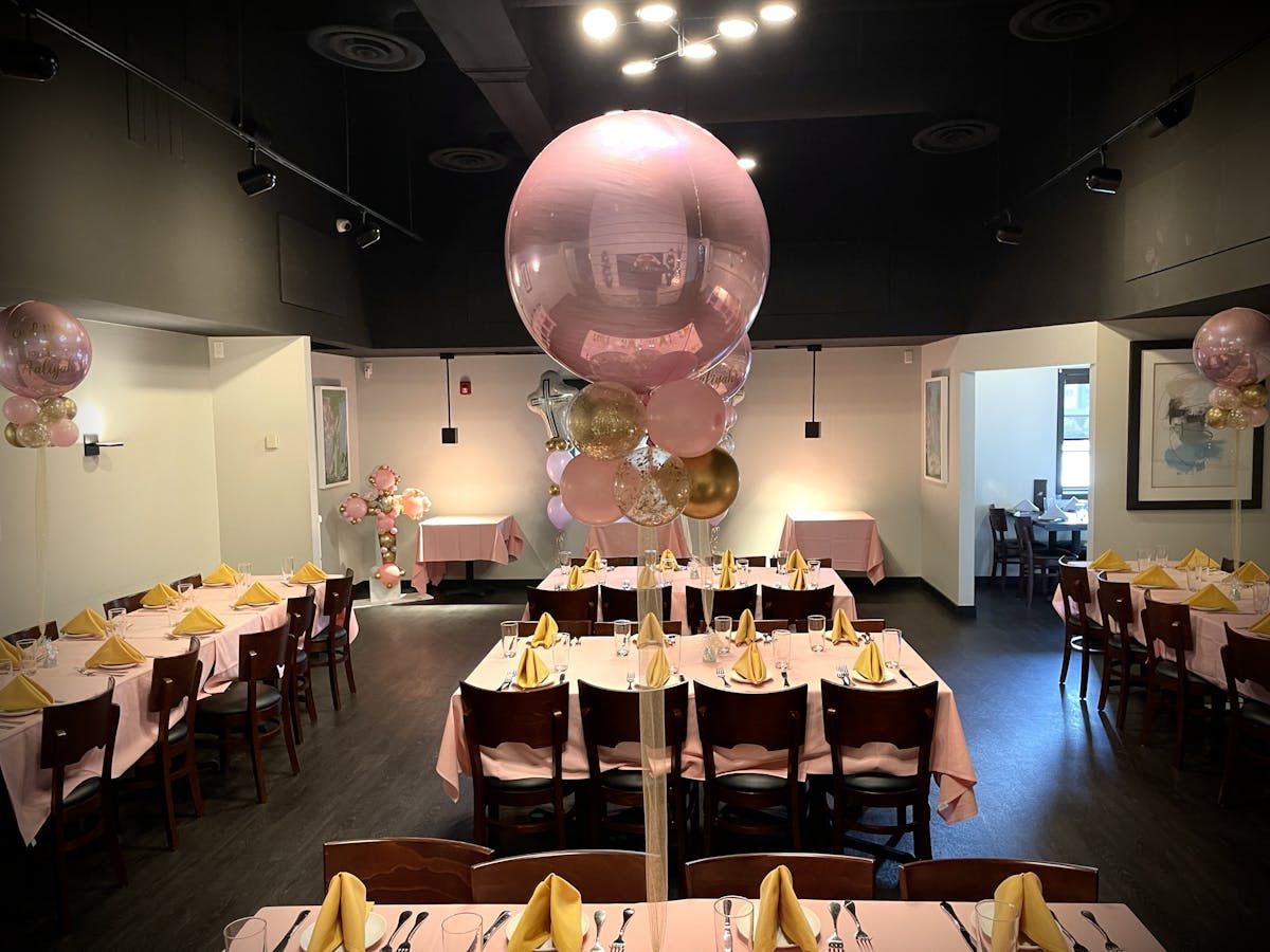 A large pink balloon is sitting on top of a table in a restaurant.