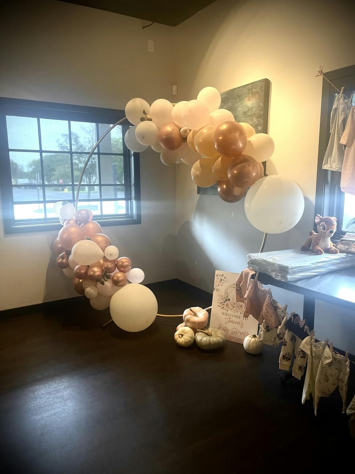 A room with a bunch of balloons on the floor and a window.