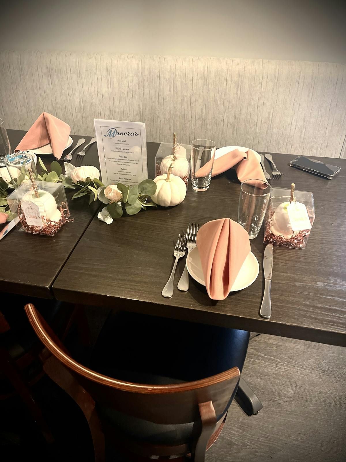 A table with plates , napkins , utensils , and pumpkins on it.
