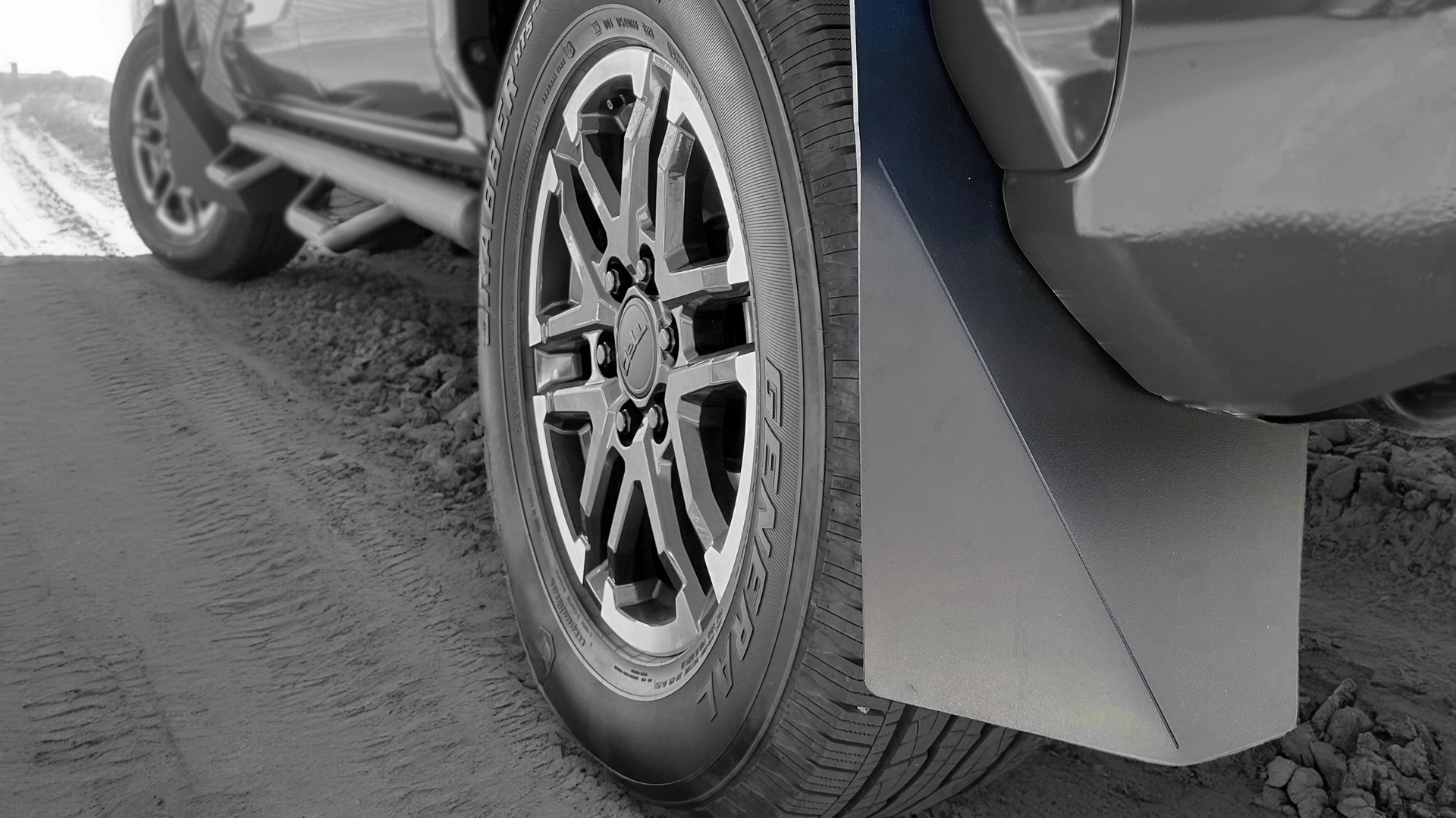 A close up of a car wheel with mud flaps on it.