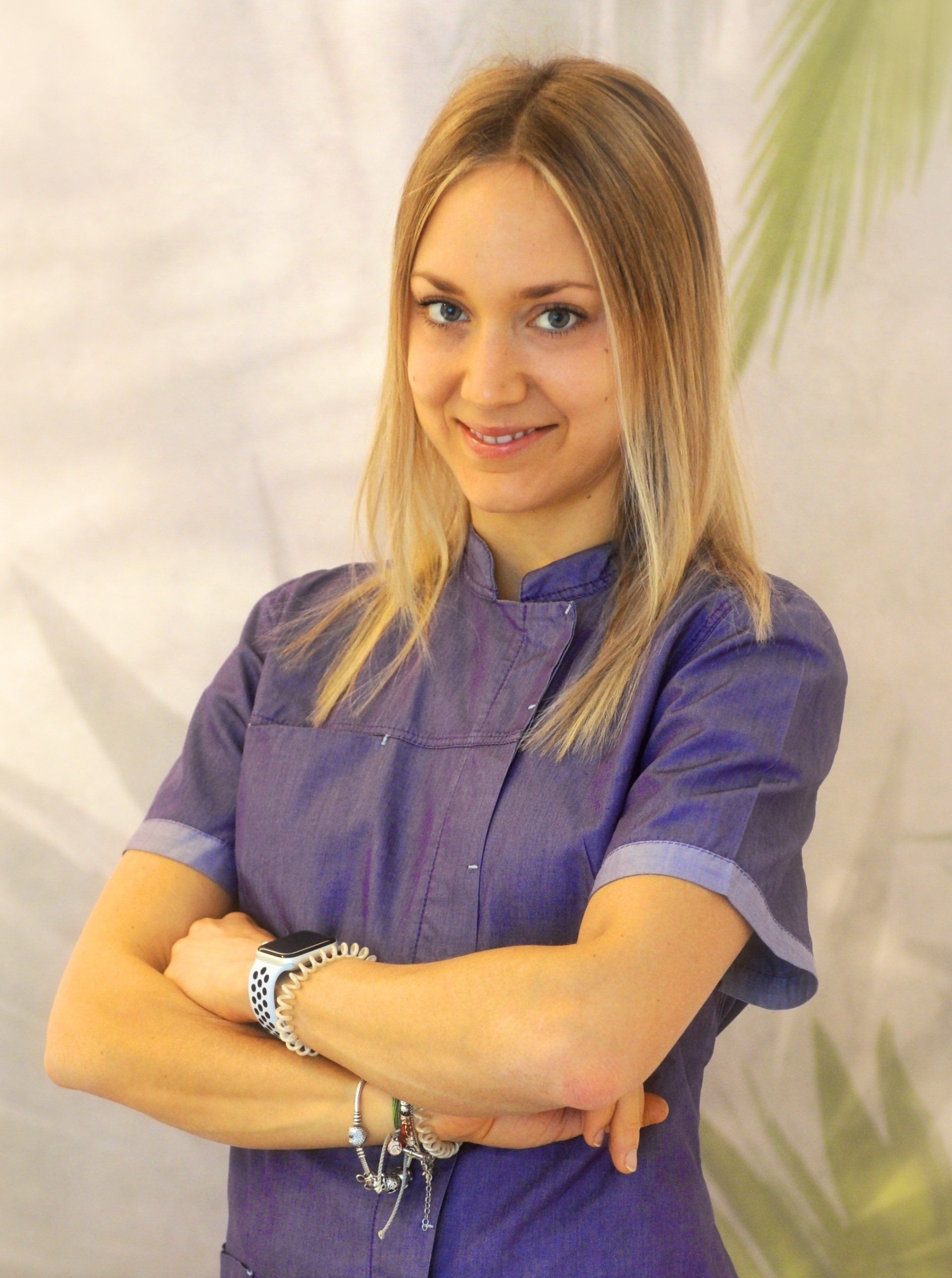 Una donna in uniforme viola con le braccia incrociate