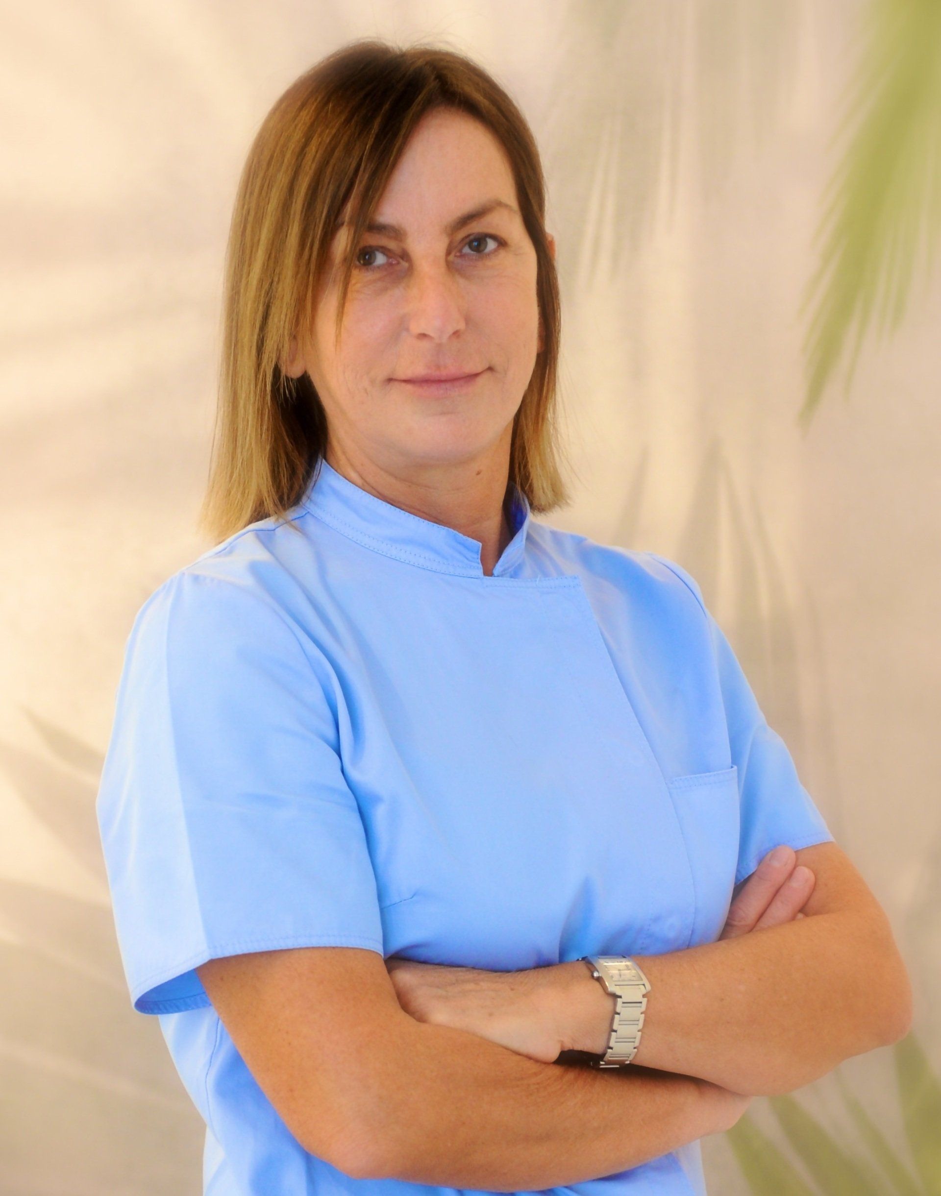 Una donna con una camicetta blu e le braccia incrociate