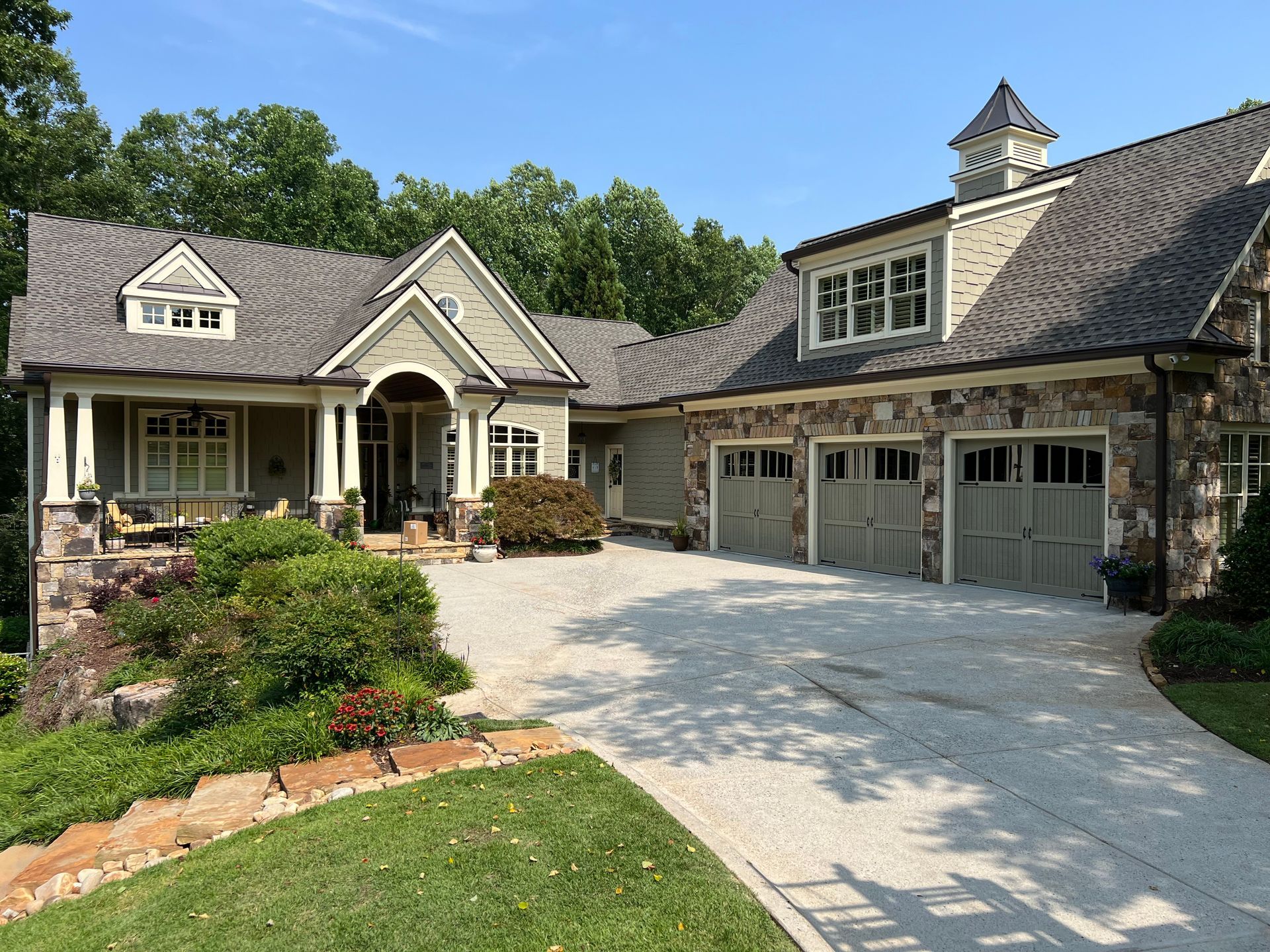 A large house with three garage doors and a large driveway.