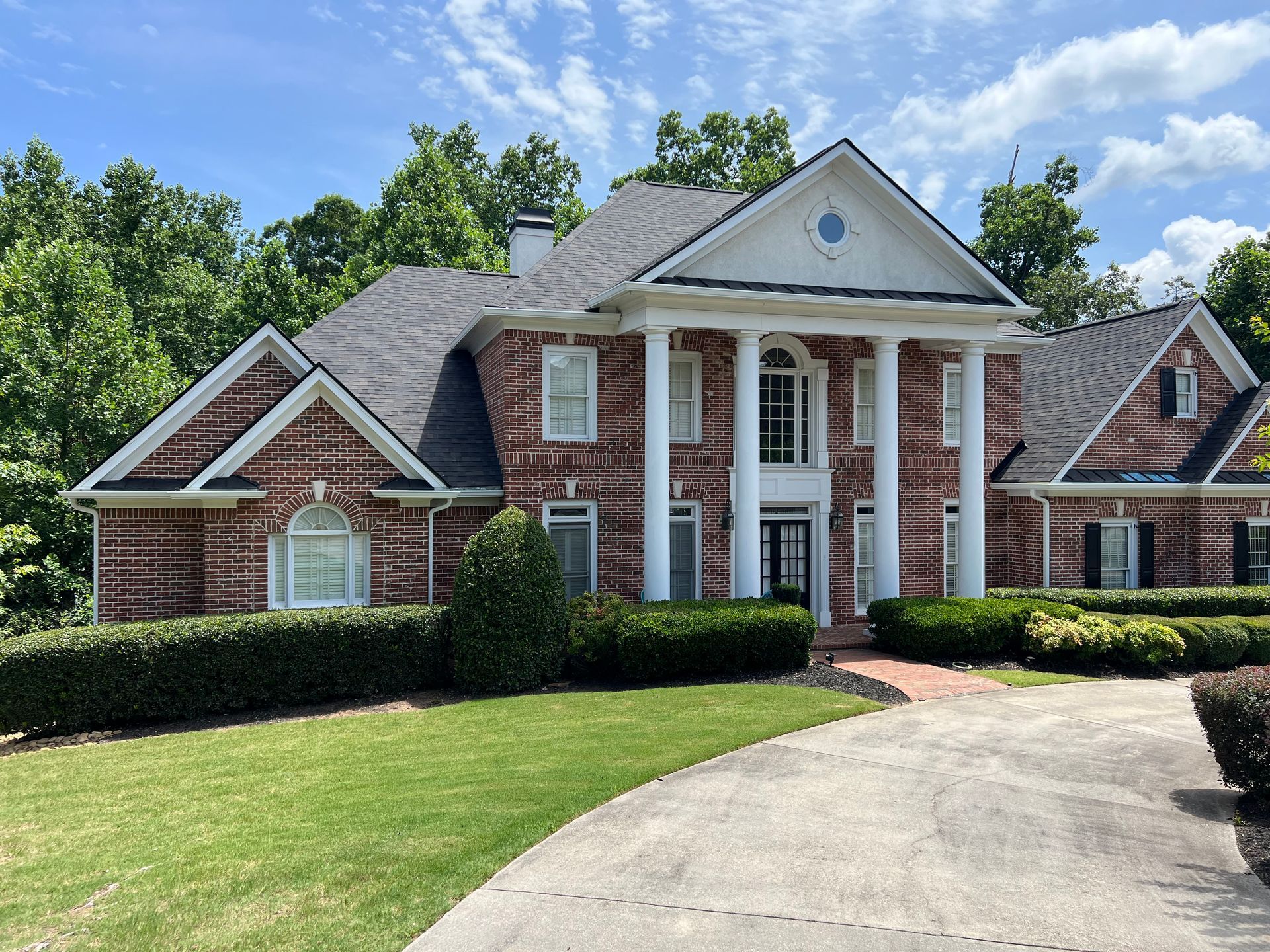 A large brick house with a driveway leading to it