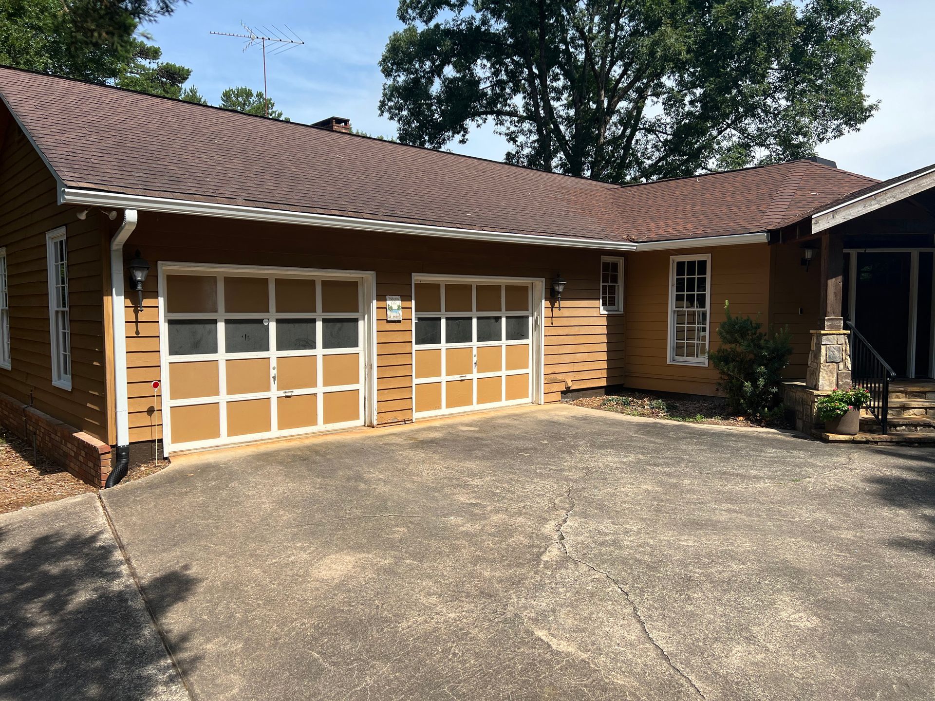 A house with two garage doors and a brown roof