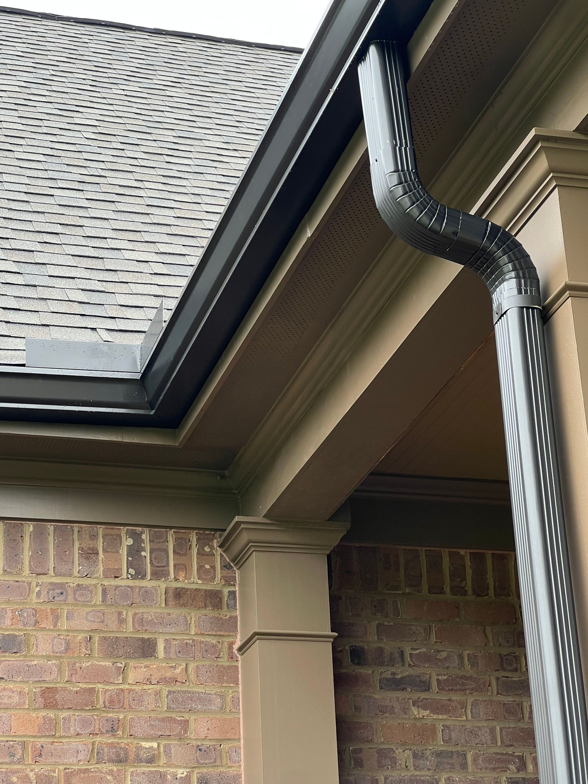 A close up of a gutter on a brick building