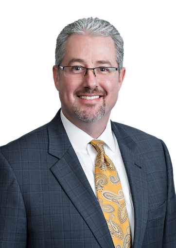 A man in a suit and tie is smiling for the camera.