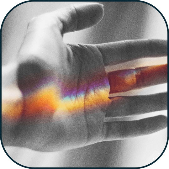 A hand with a rainbow colored reflection on it