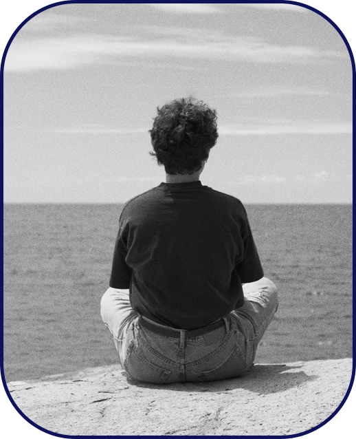 A person in deep thought staring at the ocean