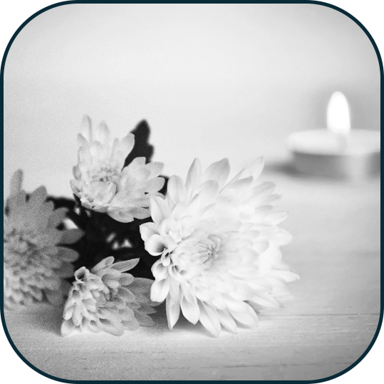 Flowers and a candle to represent commemorating the loss of a loved one