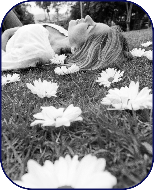 Woman at peace lying on the grass and flowers