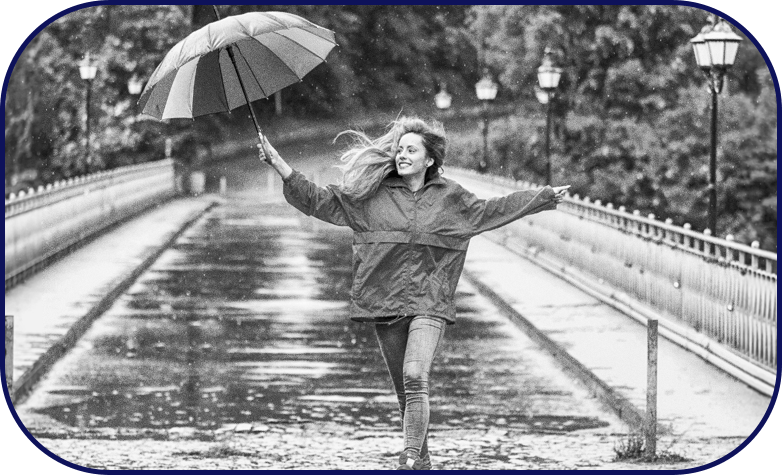 Young woman dancing in the rain with umbrella