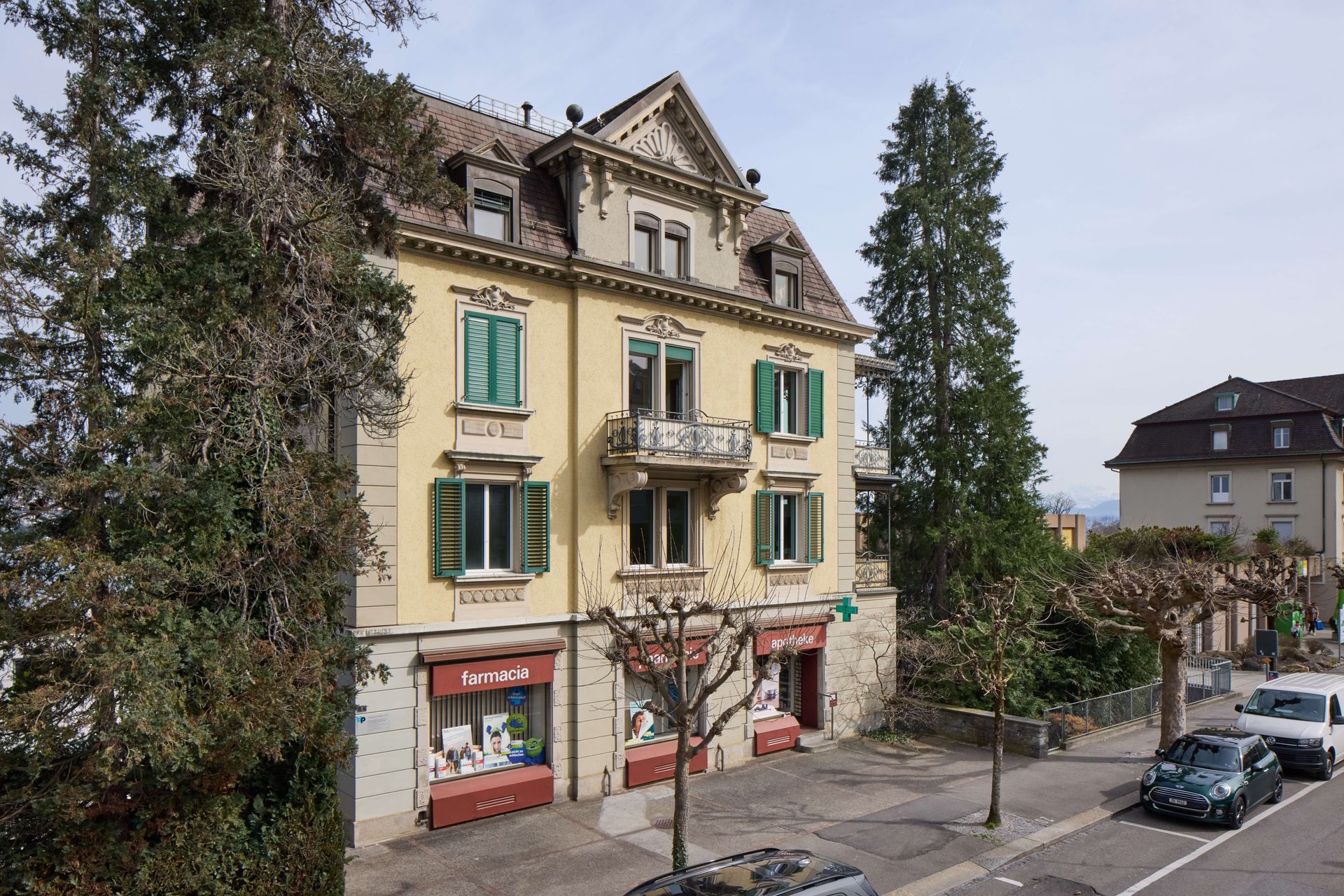 Ein grosses gelbes Gebäude mit grünen Fensterläden