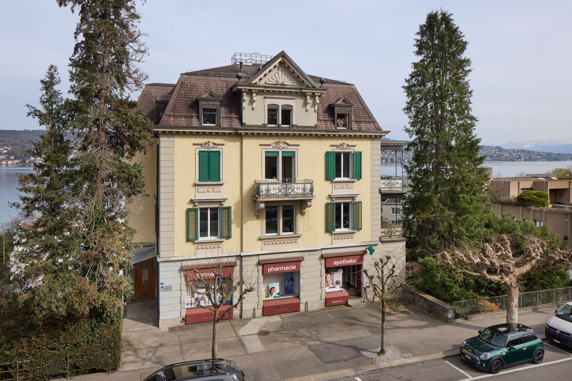 Eine Luftaufnahme eines großen gelben Gebäudes mit grünen Fensterläden