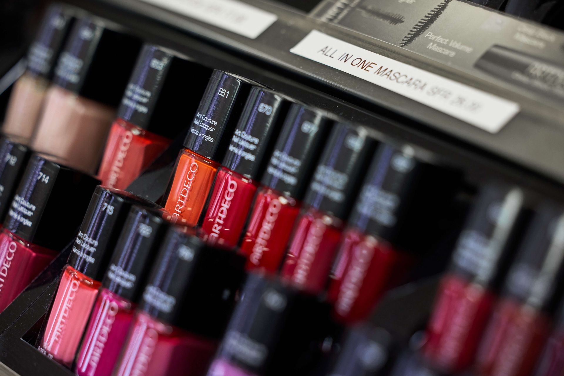 In einem Geschäft stehen auf einem Regal mehrere Lippenstifte aufgereiht.